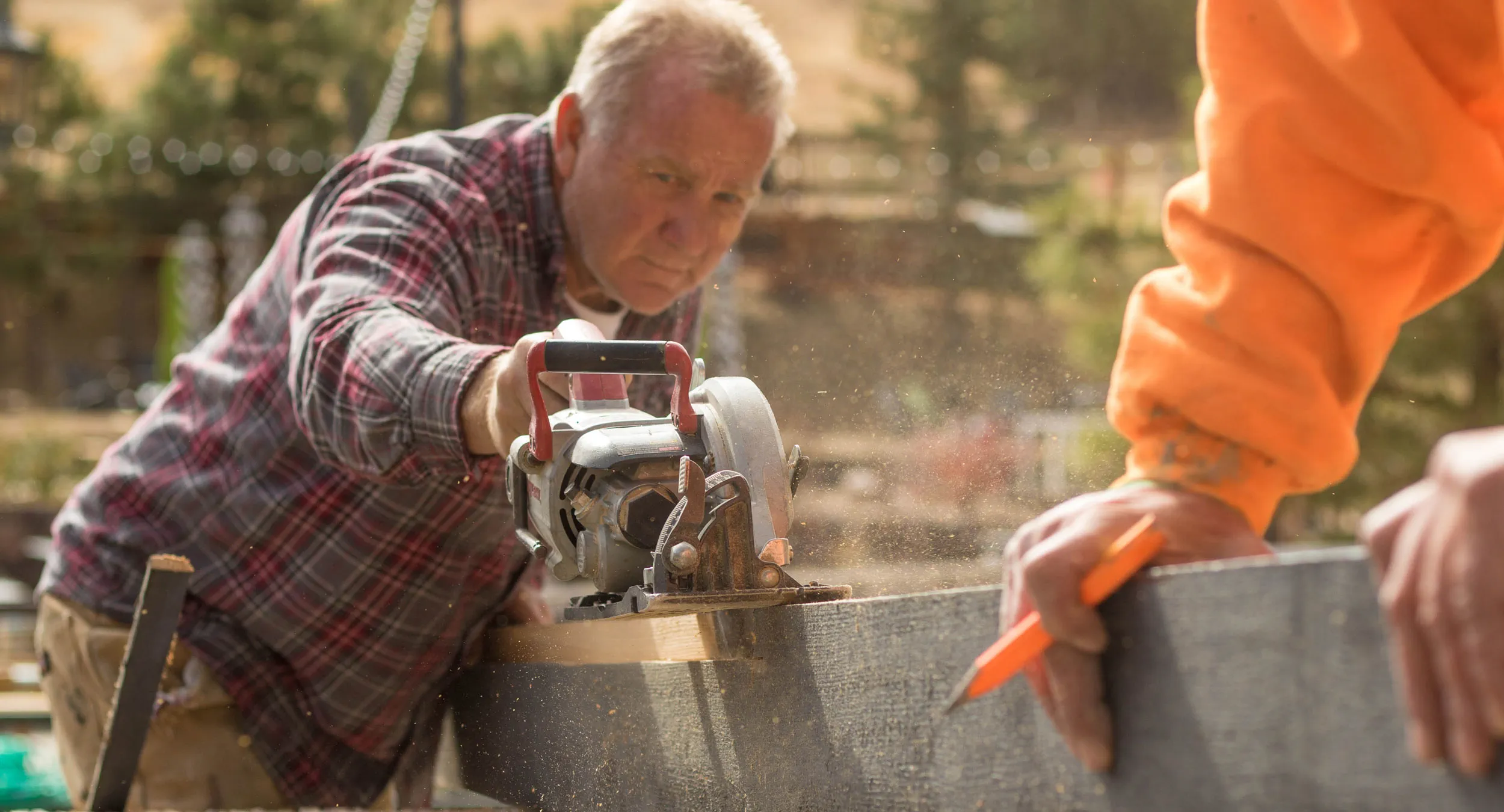 Man sawing wood, outdoors, construction workers working outdoors